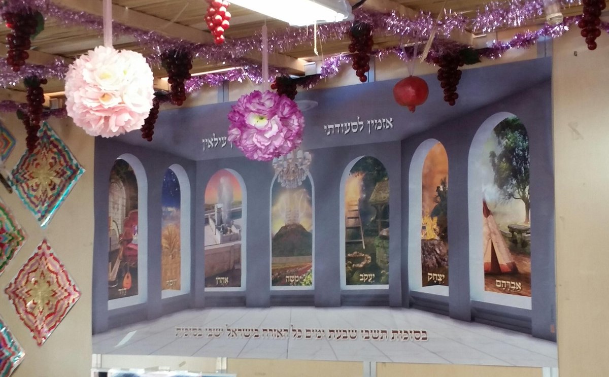 A magnificent chandelair adorns this masterpiece filled with the #ushpizin #sukkot #decoration #blessing #banner sign