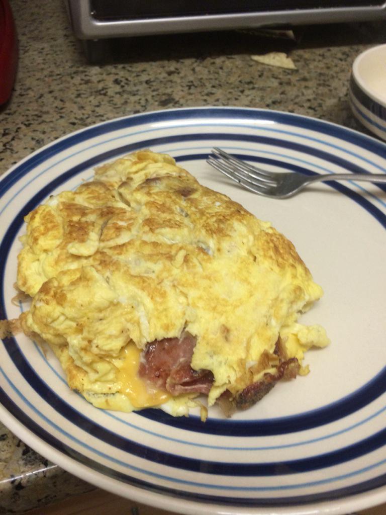 Tmackinbids3261's tweet photo. 4 eggs, 6 slices of bacon, 2 slices of American, one man, and the dream of the #perfectomelette #realized http://t.co/8wuZ1lDv9V