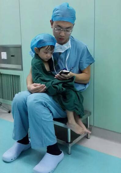【心温まる瞬間】以下の写真が中国のネットで広がっている。
女の子が手術室に入ったら突然大泣きし始め、「お父さん！お父さん」と泣き叫んだ。医師は彼女を抱き上げ、自分の娘の大好きなアニメを見せたりして慰めた。