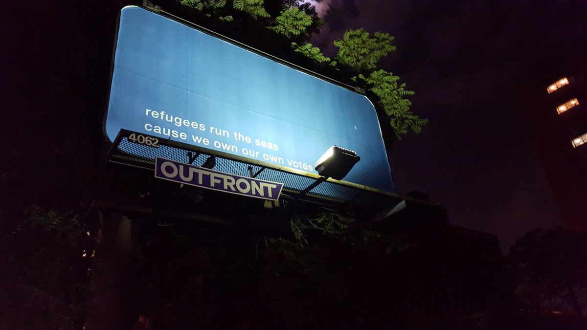 FFRadioActivism's tweet photo. billboard @gerrard/jarvis - "Refugees run the seas/because we own our own votes" a play on "hips don't lie" lyric http://t.co/sP91NlluWr