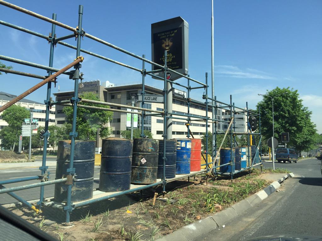 Nothing says #EcoMobility quite like digging up plants to erect scaffolding anchored by old hazardous waste drums.