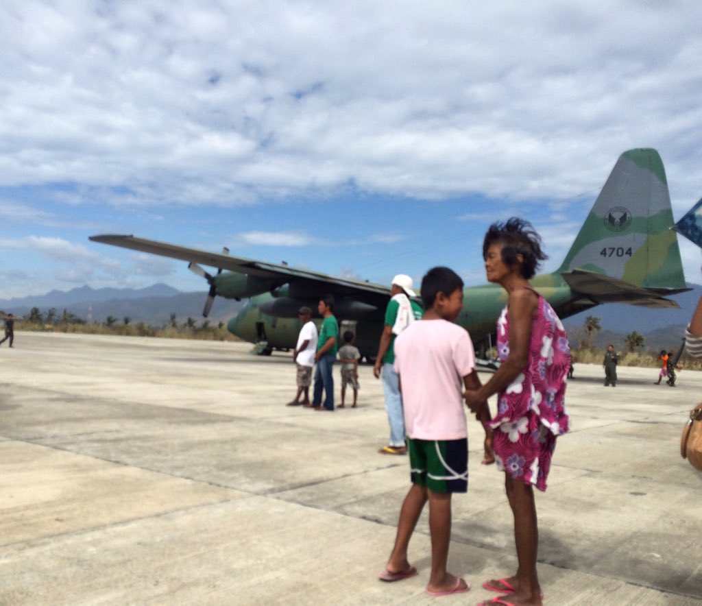 GROUND ZERO. Local residents watch as boxes of relief goods are downloaded from the first C-130 that landed in Casiguran, Aurora, following the landfall on October 18 of severe Typhoon Lando. Photo by Voltaire Tupaz/Rappler.com  