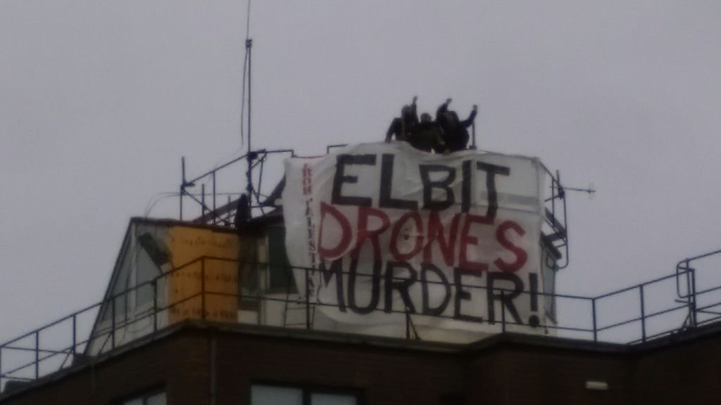 smash_edo's tweet photo. Fourth activist joins Elbit roof occupation for banner drop @BDSmovement @CAATuk @elctrncintifada #blockthefactory https://t.co/O3h0ghYmn5