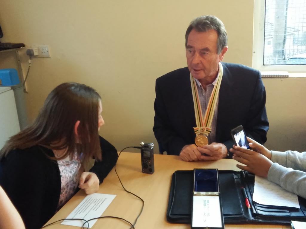 Lynn Davies being interviewed by young locals in Nantymoel. Pictured: Medal that changed his life. #WelcomeHomeLynn