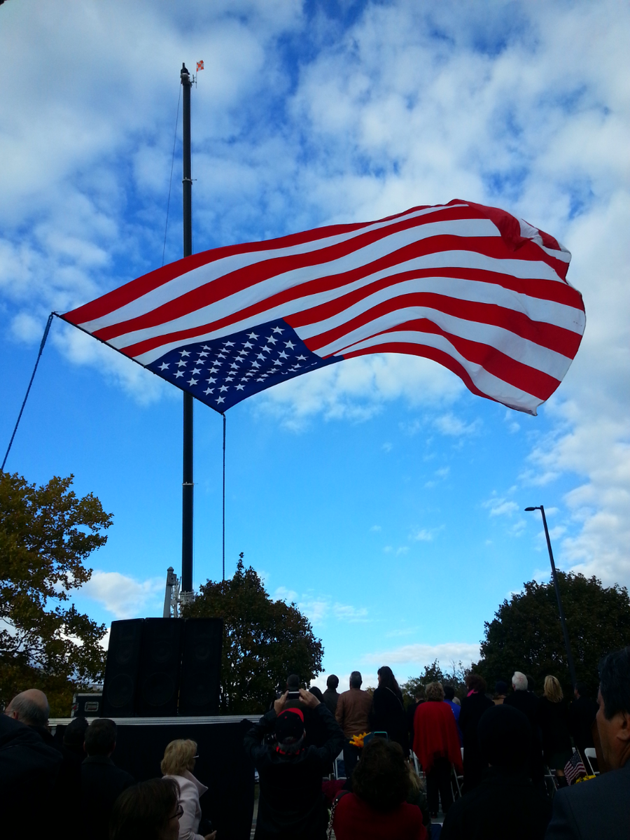 Huge American flag is unfurled @ dedication ceremony for #KrystleCampbell Peace Garden in #Medford.  #wbz #wbznews