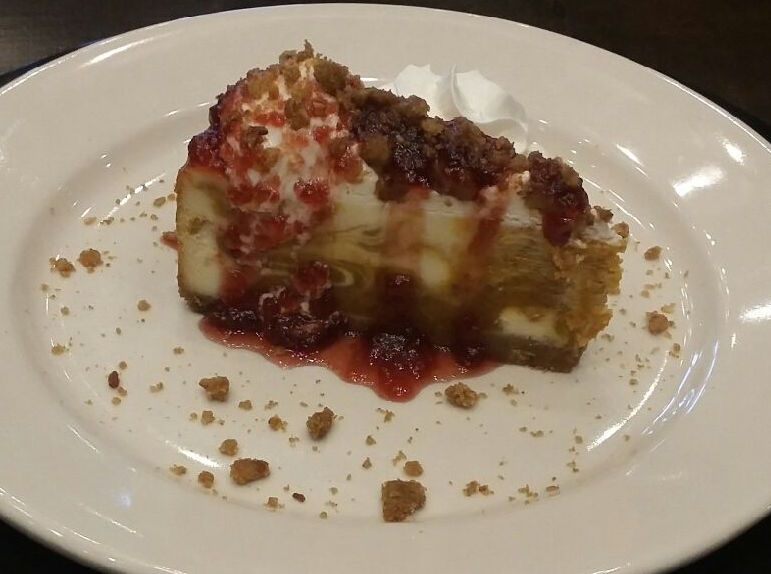 PUMPKIN SPICE CHEESECAKE: On a graham cracker crust, topped with streusel &amp; warm orange pomegranate cranberry sauce.