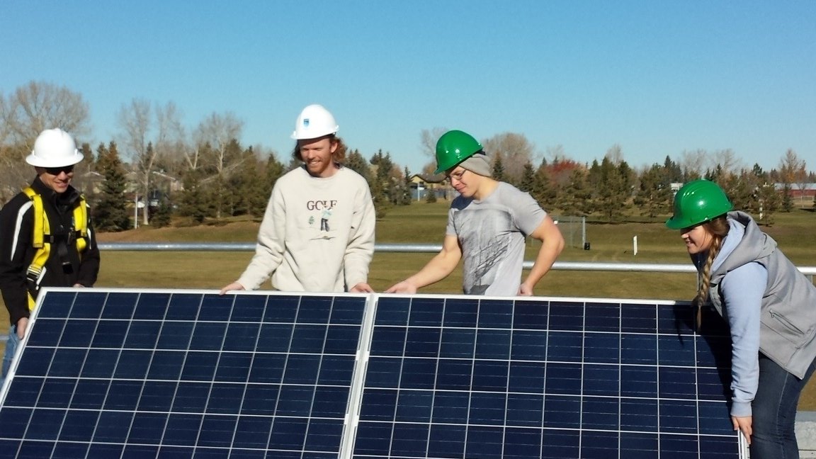 NAITAltEnergy's tweet photo. Instructor David and #AltEnergy students Charlie, Garrett and Julia putting the panels in place. @NAIT #SolarPV #yeg https://t.co/M6MJddLn9U