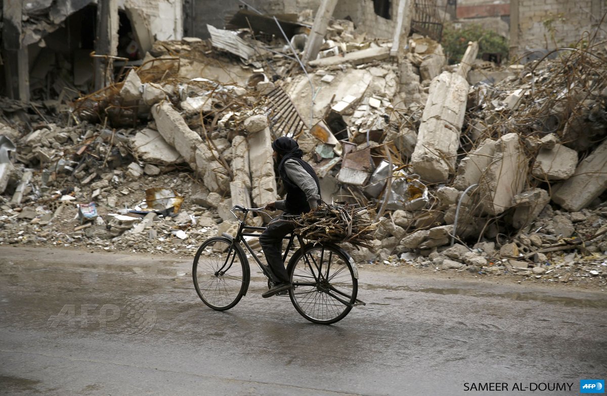 SYRIA - A Syrian man rides a bike past damaged buildings in the rebel-held area of Douma. By <a href="/SameerAlDoumy/">Sameer Al-Doumy</a>