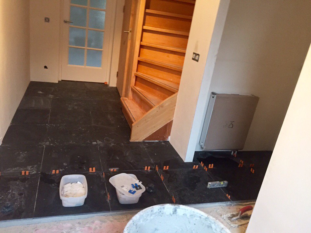 Bezig met renovatie van een hal in een woonhuis #belgisch #hardstenen #tegels #donker #gezoet
