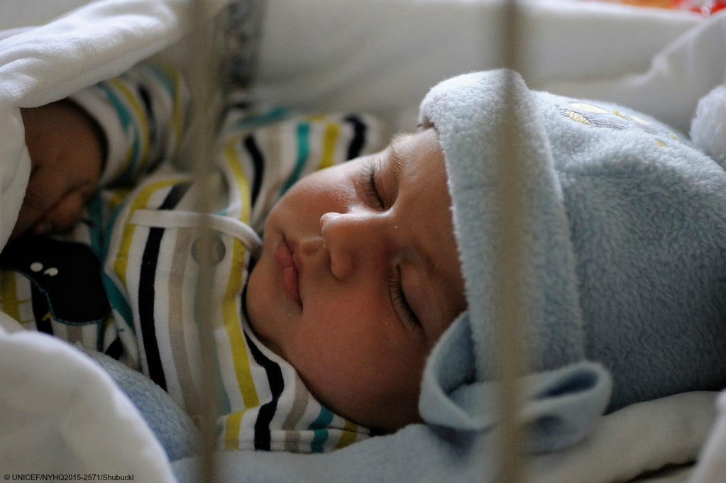 UNICEF's tweet photo. A baby sleeps under a blanket at a reception centre for refugees and migrants in #Serbia #refugeecrisis https://t.co/odaaZtnfbs