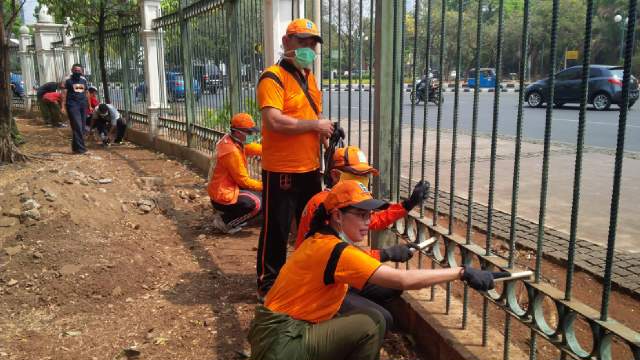 Ka sudin Kebersihan sdg melaksanakan pengamplasan pagar monas