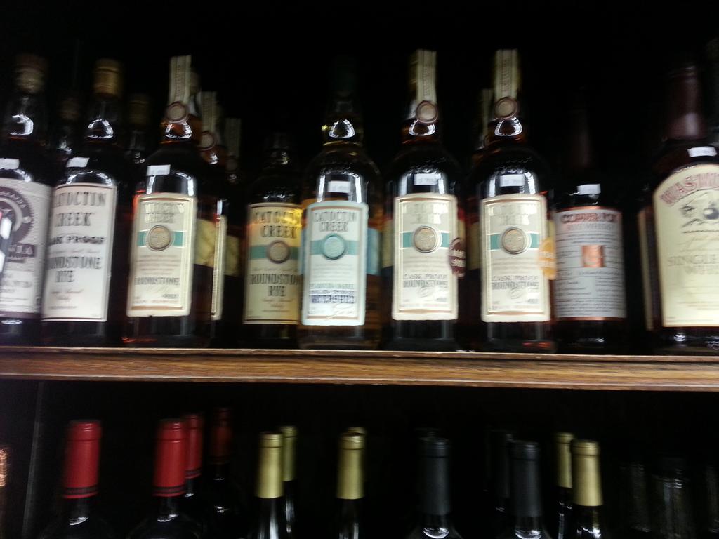 A lovely (if blurry) scene: #drinklocal #vawhiskey shelf at <a href="/PotomacWines/">Potomac Wines</a> in #Georgetown w/ so much @catoctincreek!
