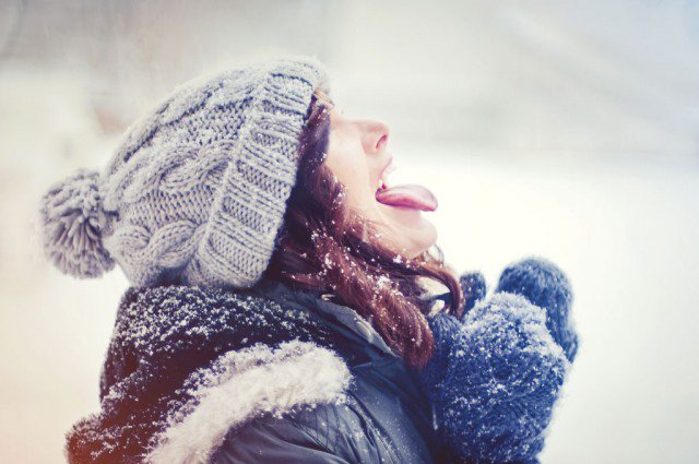 радость зимой. девушка ест снег. ребенок ловит снег ртом. ребенок ловит снежинки. ловить снежинки ртом.