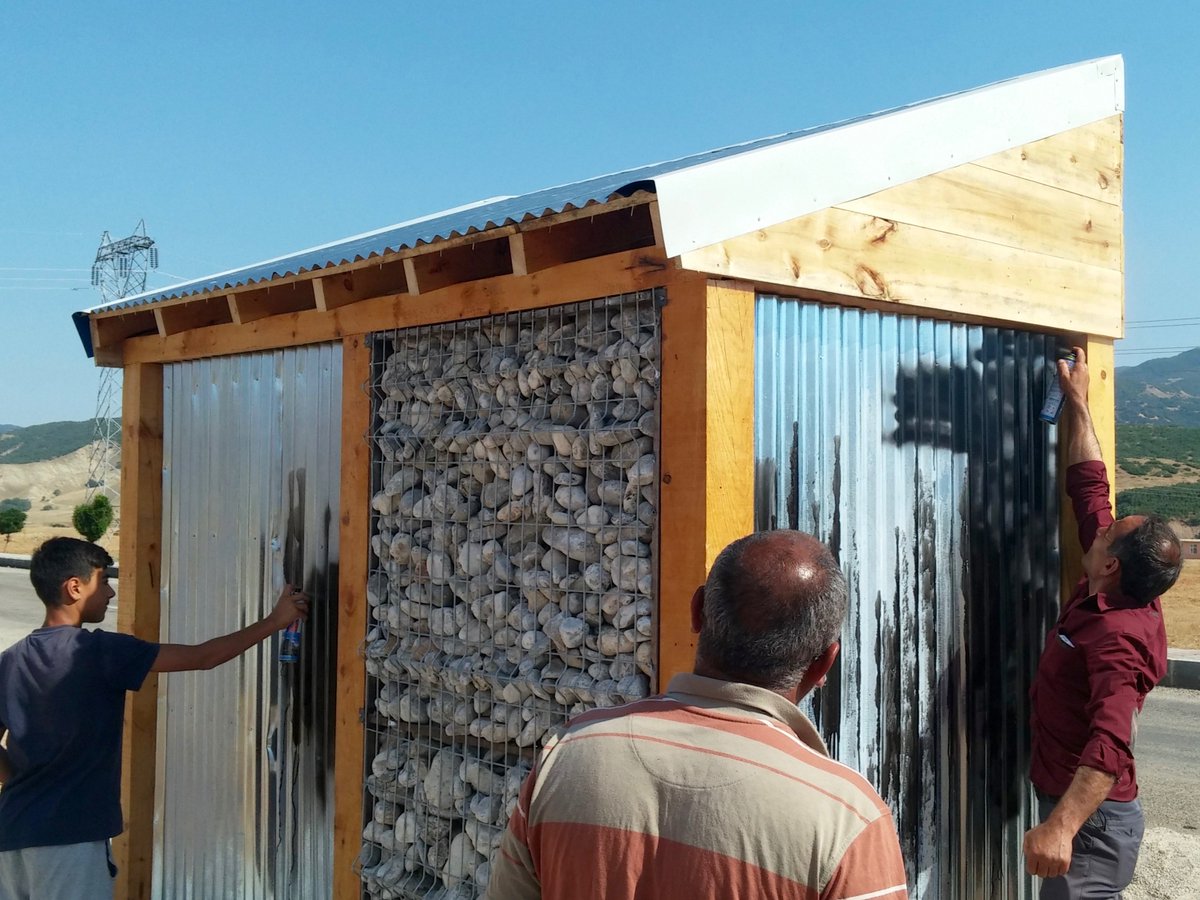 cephelerdeki saclar boyanıyor, ozan da bize yardım ediyor. / painting the galvanized sheets with ozan's assistance.