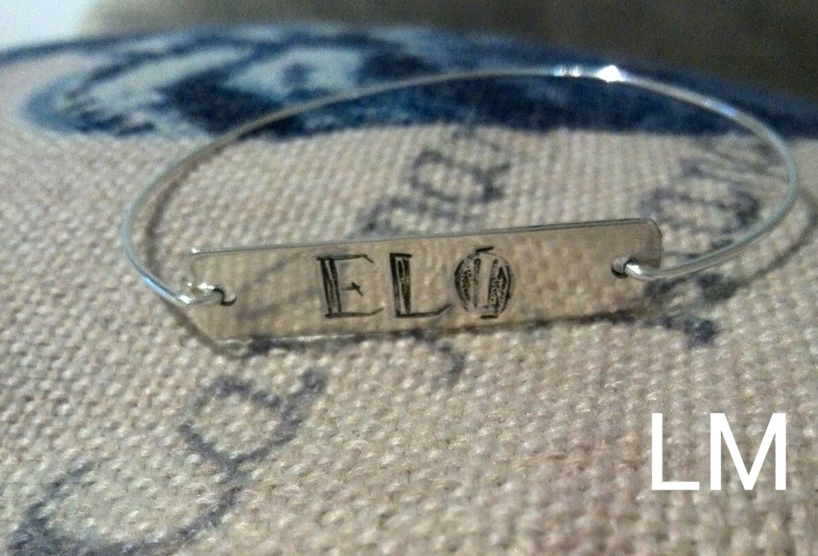 Diseño en pulsera rígida plata de ley. Medalla repujada a mano