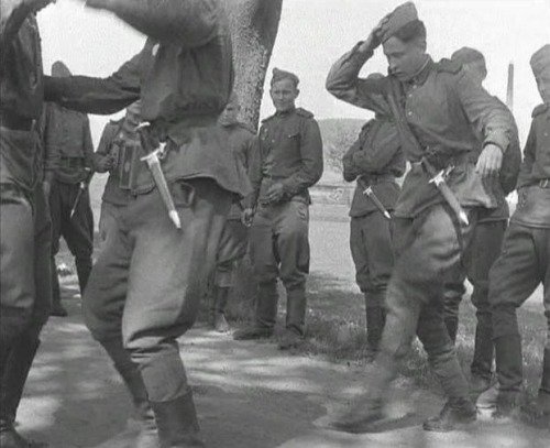Soviet soldiers dancing, wearing German knives as trophies./