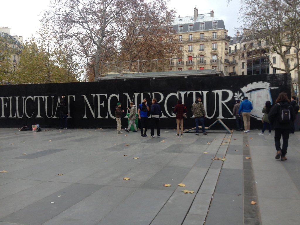 nicolaschapuis's tweet image. Place de la République, des graffeurs taguent en énorme la devise de Paris "elle flotte mais ne coule pas".