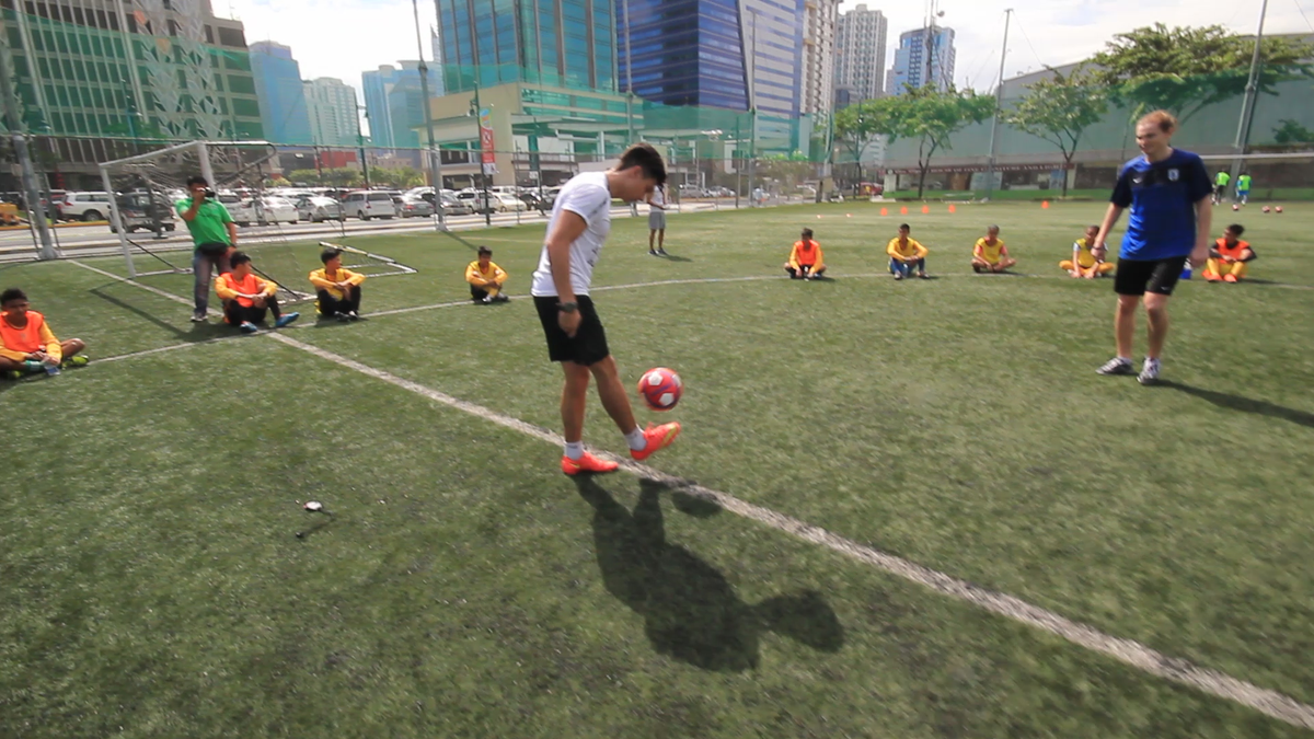 JambaJuicePH's tweet photo. Here's Jamba Juice #ImpossibleMove Manila coach @MarkEMcMahon showing young footballers how he bends it like Beckham https://t.co/Art5m44nVM
