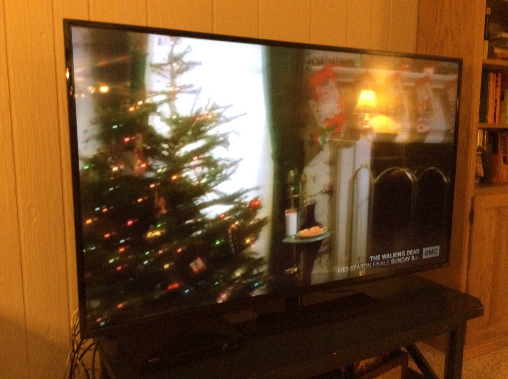 ReadByExample's tweet photo. Nothing says Christmas like a constant promo about zombie TV in the corner of a holiday movie! @AMC_TV #snarkchat https://t.co/yZokUhpyhs