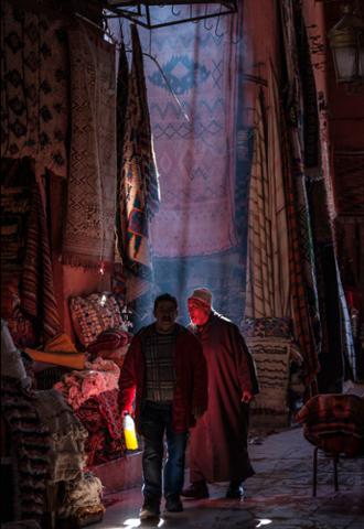 MagnumPhotos's tweet photo. Morocco. #Marrakesh. Falling light over the carpet soukh with a man holding a yellow bottle. © #Abbas/ #MagnumPhotos https://t.co/tpBySOA6sO