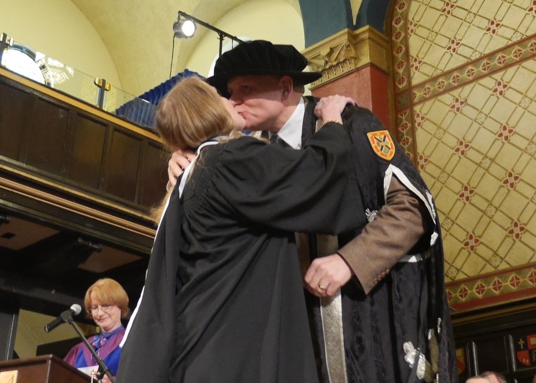 queensualumni's tweet photo. Special moment during #QGrad15 as @queensprincipal kisses his wife and new @Queensu graduate @jagwoolf. https://t.co/kMAg5Edgpy