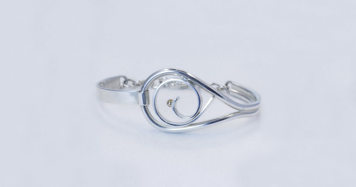 A sterling and 14k yellow gold "Moments" bracelet.  By local artist Lynda Constantine.