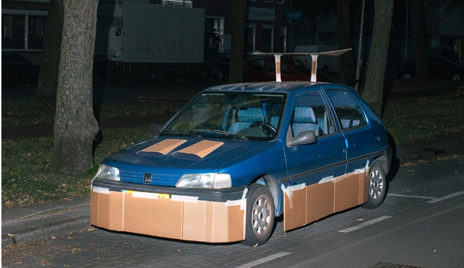 VICE's tweet photo. This guy walks the streets at night pimping strangers' rides with cardboard: https://t.co/sHrLCNt3oW https://t.co/aZdKRNwFq8
