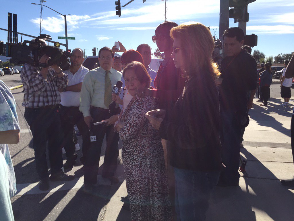 Worried friends and family check phones for word of loved ones. (Sarah Parvini / Los Angeles Times)