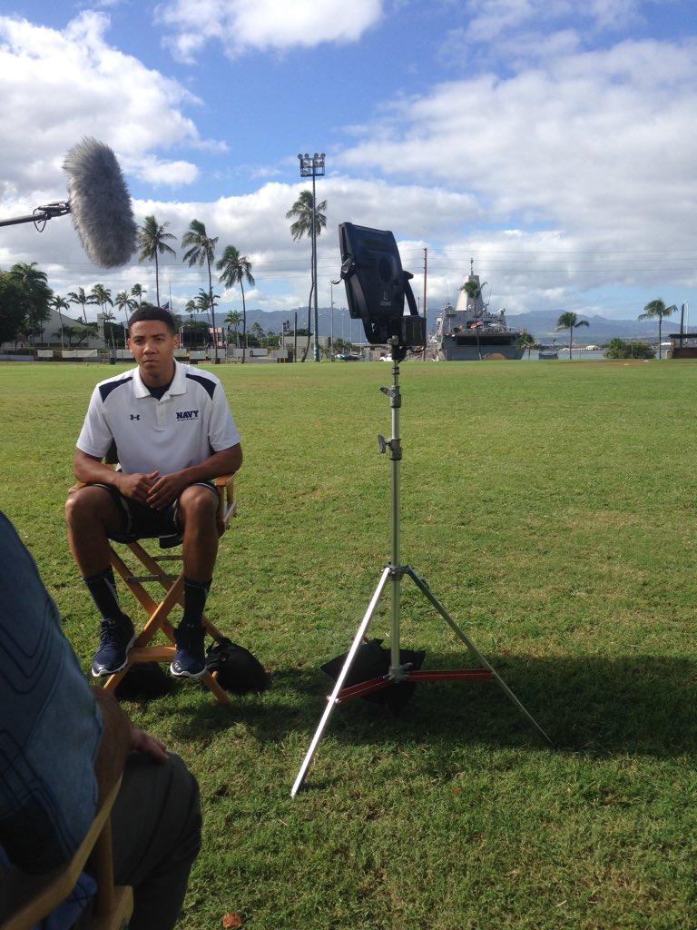NavyAthletics's tweet photo. #NavyMBB's Shawn Anderson does an interview with @FOXSports at Pearl Harbor with some Navy ships in the background. https://t.co/k7iwjXNtC3