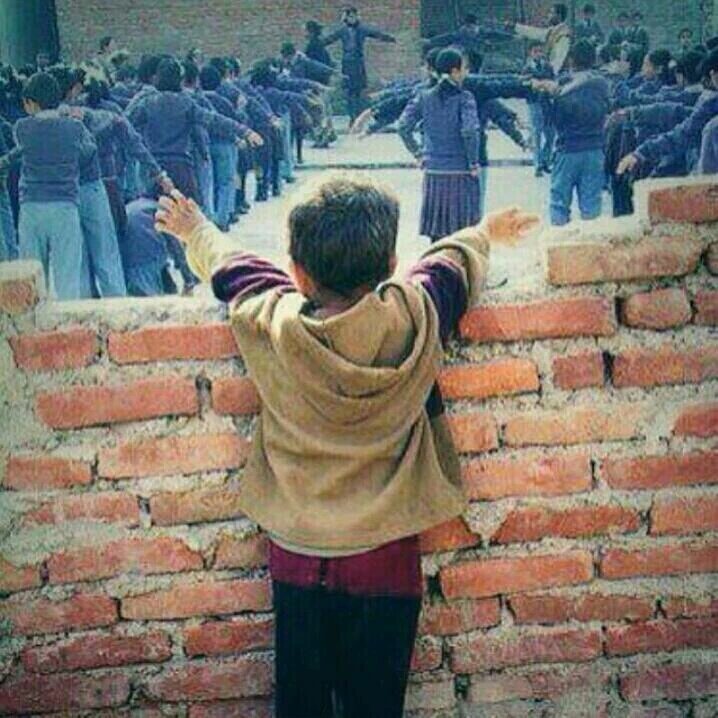 صورة مؤثرة: طفل محروم من المدرسة يرى أطفالا في نفس عمره يمارسون طابور الصباح، وكأن حلمه أمامه ولا يتحقق !