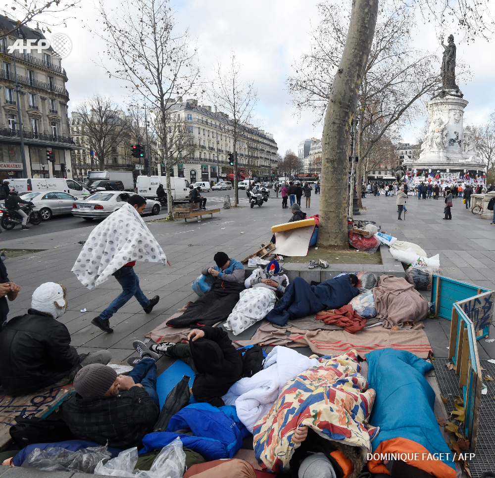 afpfr's tweet photo. A deux pas des fleurs et bougies de la place de la République, des migrants afghans https://t.co/SmFTfJyJuJ  #AFP https://t.co/Nlw2TSd1vr