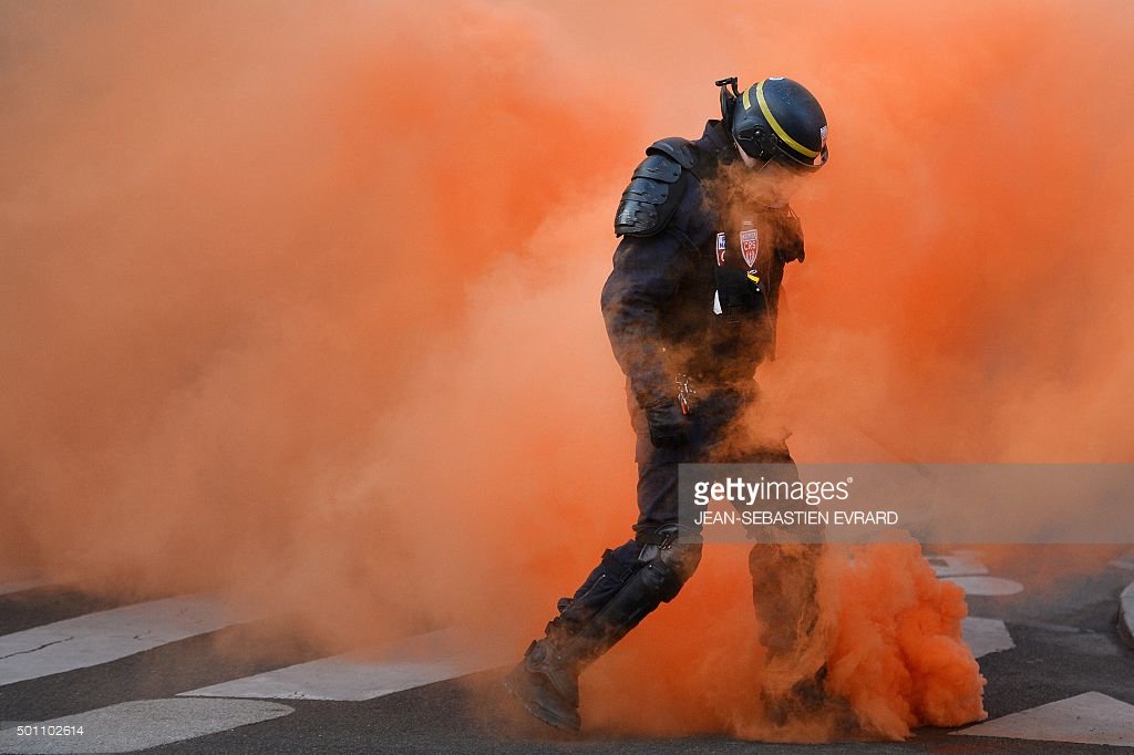 GettyImagesNews's tweet photo. An anti-riot policeman walks through orange smoke from teargas during demo in Nantes @AFP https://t.co/8fJxfIQNV6 https://t.co/rKvwEmNQGD