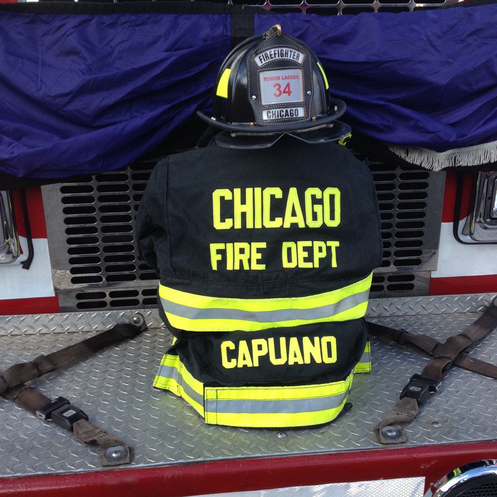Firefighter Dan Capuano's coat and helmet on front of Engine 72 outside St Rita