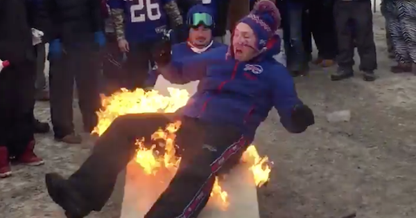 VIDEO: Bills fan catches fire after jumping through flaming table, gets put out with beer. thesco.re/1mYrINy
