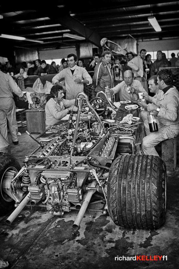 The flanks of 312 #ferrari serve as a table for mechanics. #tortellini and #lambrusco for theirs dinner.'77 Usa Gp
