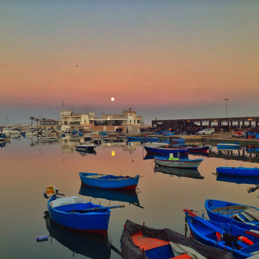 Caroppio's tweet photo. La luna in mare e una città in festa: Bari, il 24 dicembre, è da vivere. #WeAreinPuglia https://t.co/xnLvf5Ss4s https://t.co/akE6vYjK9P