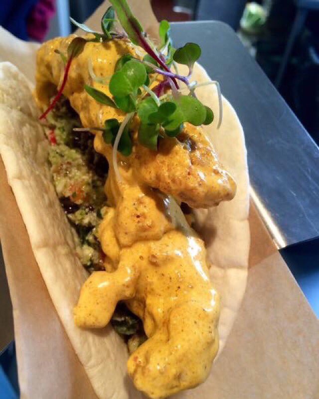 A Moroccan cauliflower cous cous salad topped with fried chicken tenders dipped in a curry sauce.