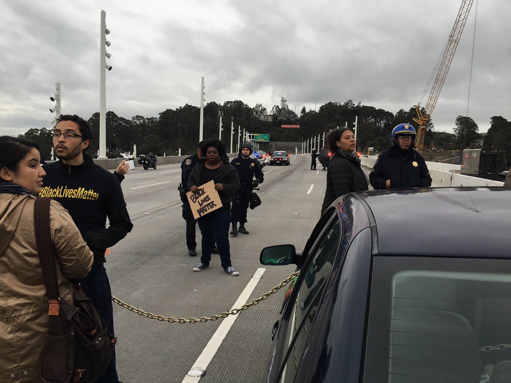brownblaze's tweet photo. activists are chained by the waist on the Bay Bridge. #96hours #ReclaimMLK https://t.co/bSJhjBglsJ