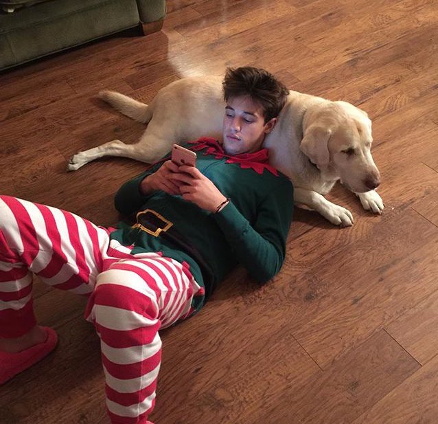 Asher_David_'s tweet photo. Just laying there, texting, on the dog, in his elf onsie and pink fuzzy socks. Yep. Thats Gun for ya. @Gunner_David_ https://t.co/B0Fw8nJycj