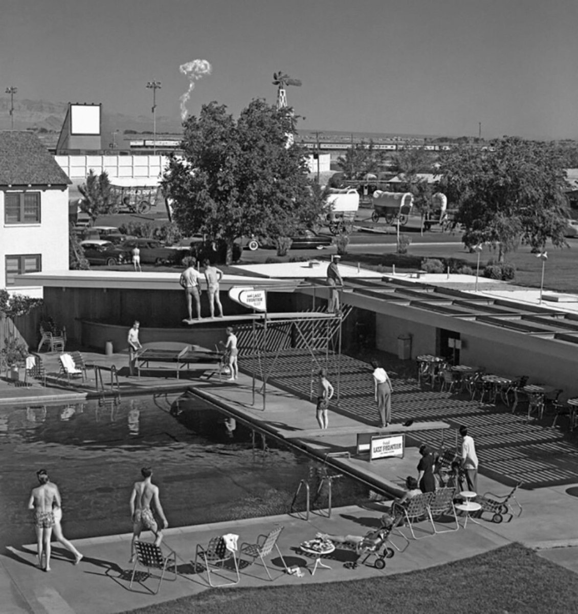 HowThingsWere's tweet image. Swimmers at a Las Vegas hotel watch a mushroom cloud from an atomic test 75 miles away (1953)