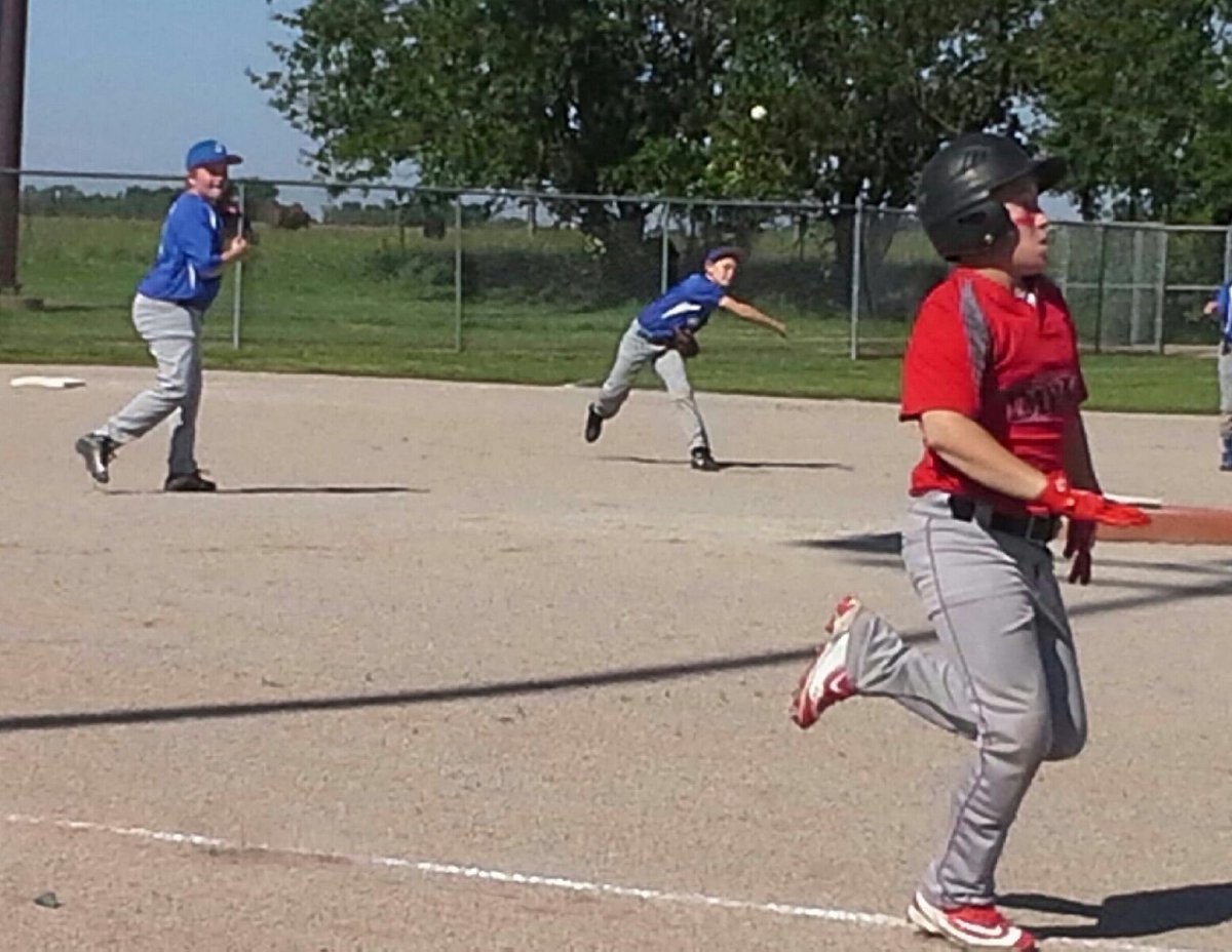 ChampionDiamond's tweet photo. Carson Roskop whistles the ball to first from the hot corner for the Sluggers as Justin Payne hustles down the line for the Impact https://t.co/z7swliy6yw