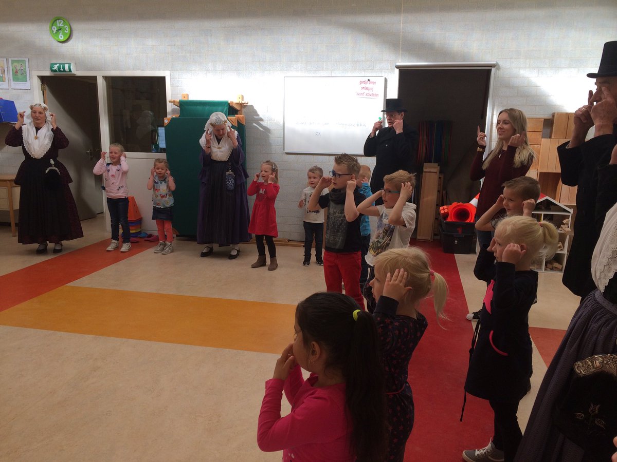 De dansgroep van 't Aol Volk geeft de kleuters een dansworkshop en uitleg over de kleding van vroeger.#thema#erfgoed.