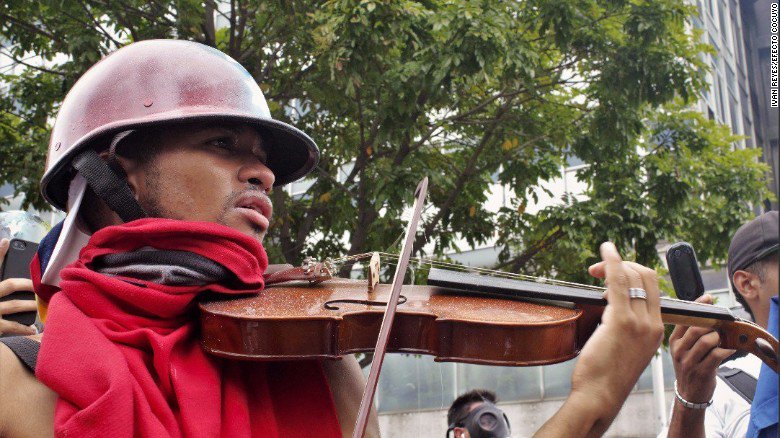 Ramlyyusof2's tweet photo. In the middle of a protest in Venezuela, a violinist plays the national anthem as tear... https://t.co/yiaZPIKryE by #CNN via @c0nvey https://t.co/LxAOSsYCB8