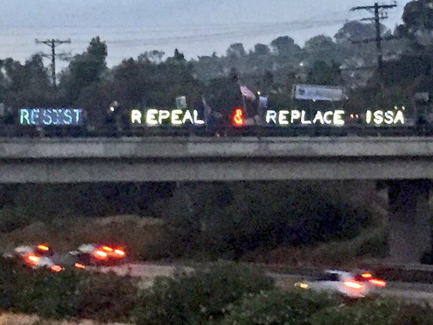 KimPiker's tweet photo. Last night at a freeway overpass in Darrel Issa’s district
He sold us out for an #AHCAPayoff
#WhyIsIssaInFL
#PayBackRecess https://t.co/fHtUVDezr0