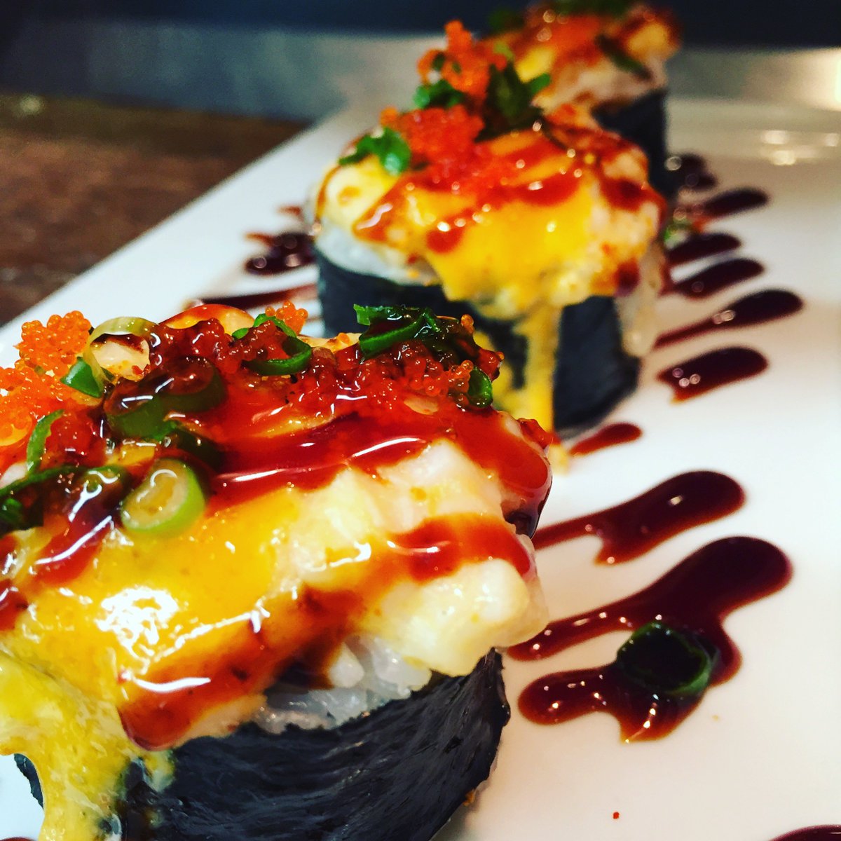 Hand Grenades. Seaweed wrapped around shrimp, wrapped around rice, topped w/ spicy Scallops, spicy mayo, tobiko, scallion. Baked and torched