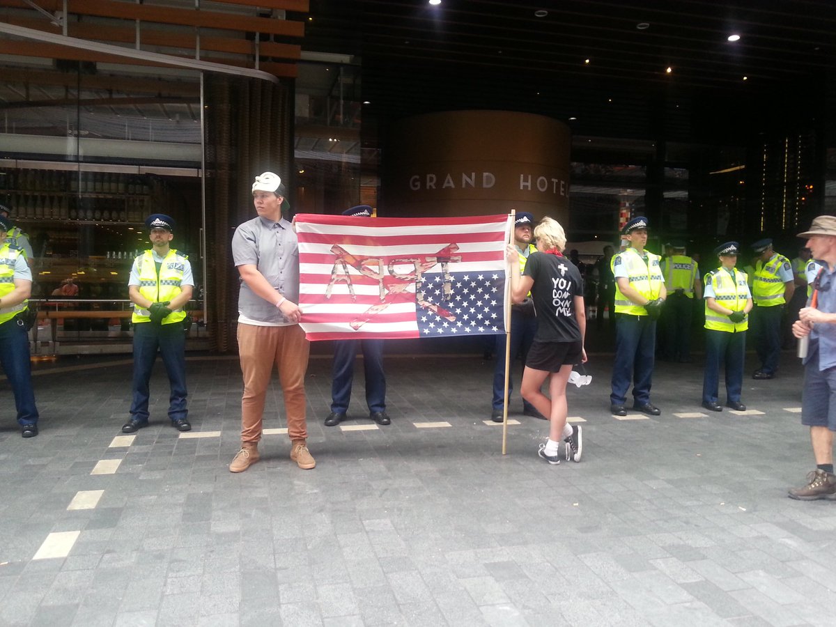 350nz's tweet photo. Staredown with the police in front of the Grand Hotel #TPPA #TPPAFreeZone #TPPABlockade https://t.co/ZrjU4s74zQ