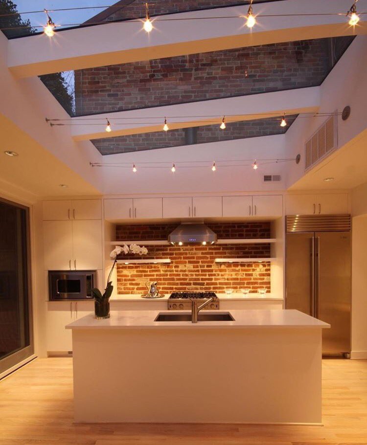 We love the balance between lighting, #marble counters and wood elements in this kitchen!