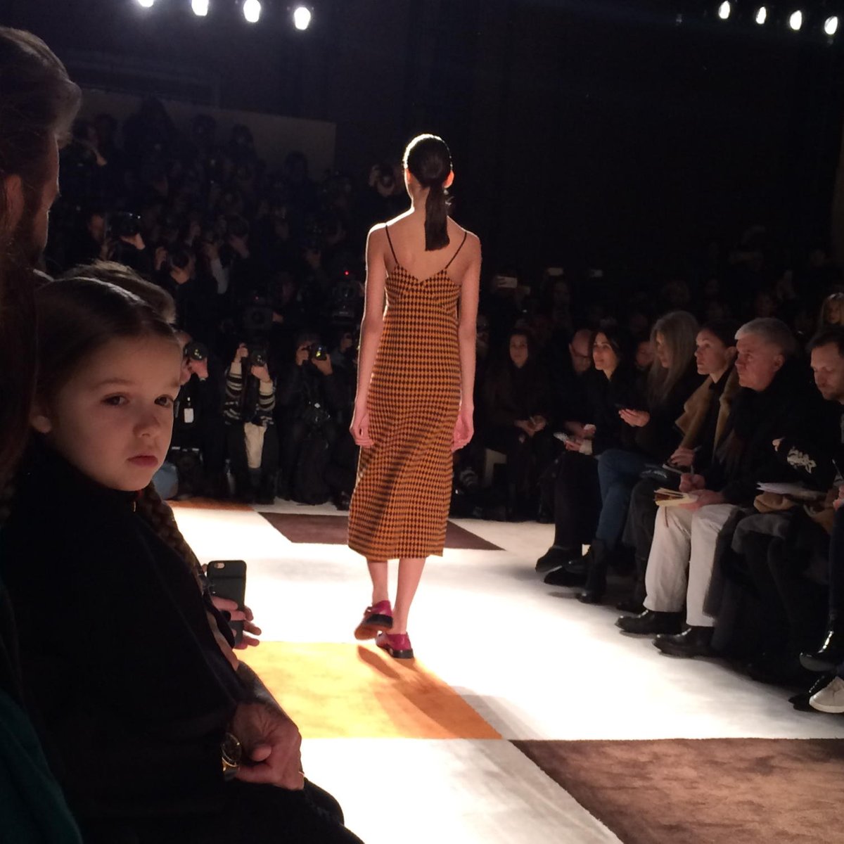 Harper Beckham, age 4, seems mesmerized by Victoria's fall runway show in NY this morning