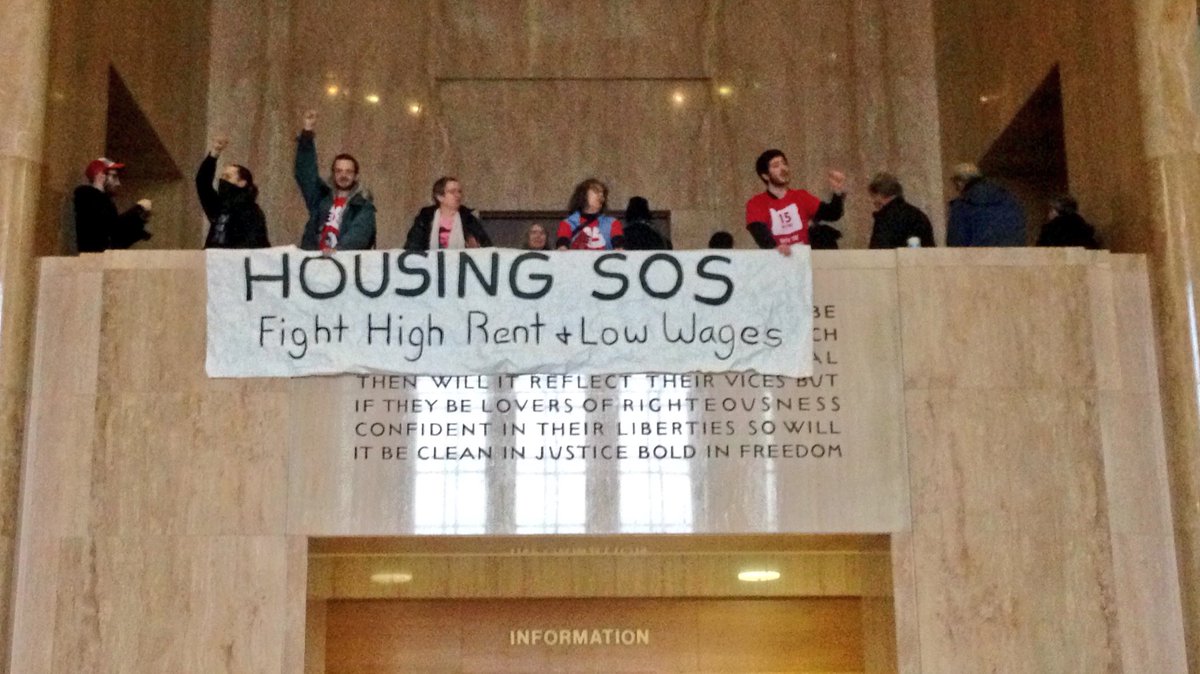 Banner drop over the balcony near Gov's office demanding an end to high rent and poverty wages! <a href="/15NowPDX/">15 Now Pdx</a>
