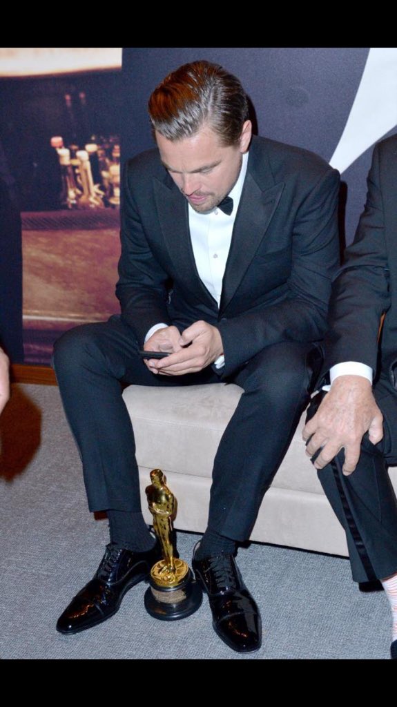 Leonardo DiCaprio in Oscar playing with mobile phone